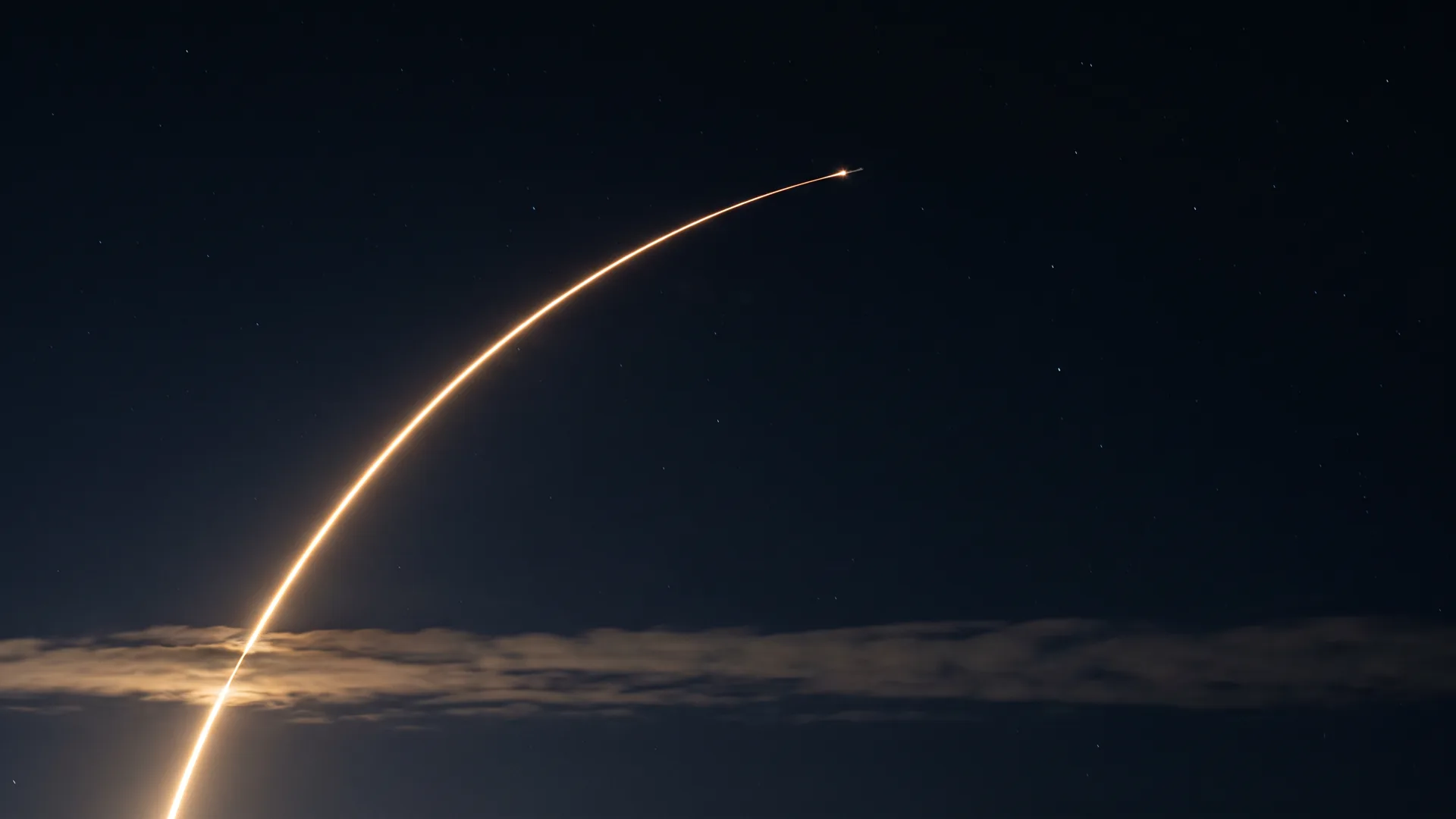 A single launch trail drawn as one long gold arc climbing from the lower left into a black sky